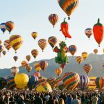 Hundreds of colorful hot air balloons lifting off during the Albuquerque International Balloon Fiesta mass ascension at sunrise over Balloon Fiesta Park