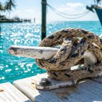 Braided marine rope secured to a dock cleat under Florida sun.